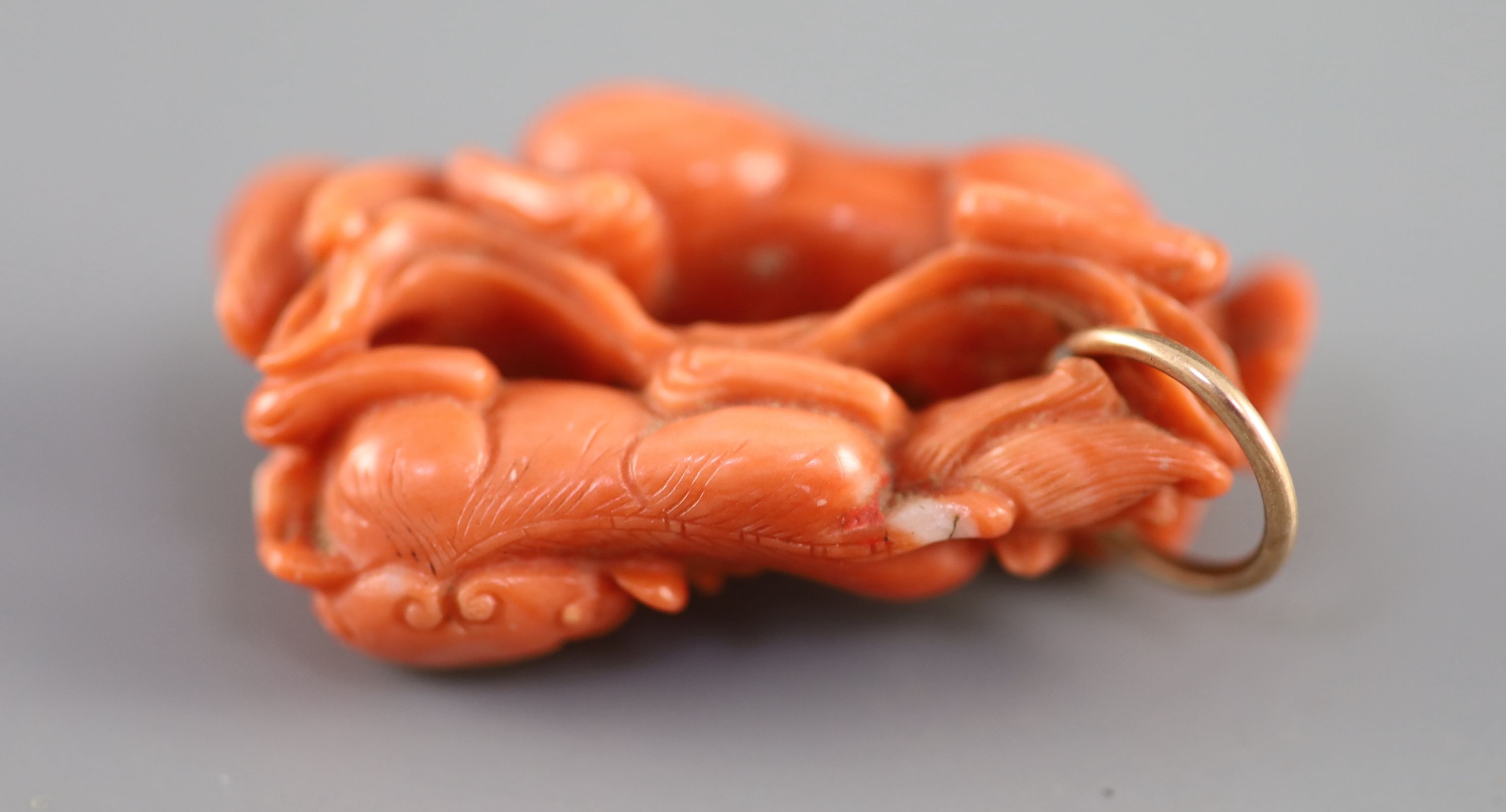 A Chinese coral ‘lion-dog’ pendant, 19 century, 3.8cm